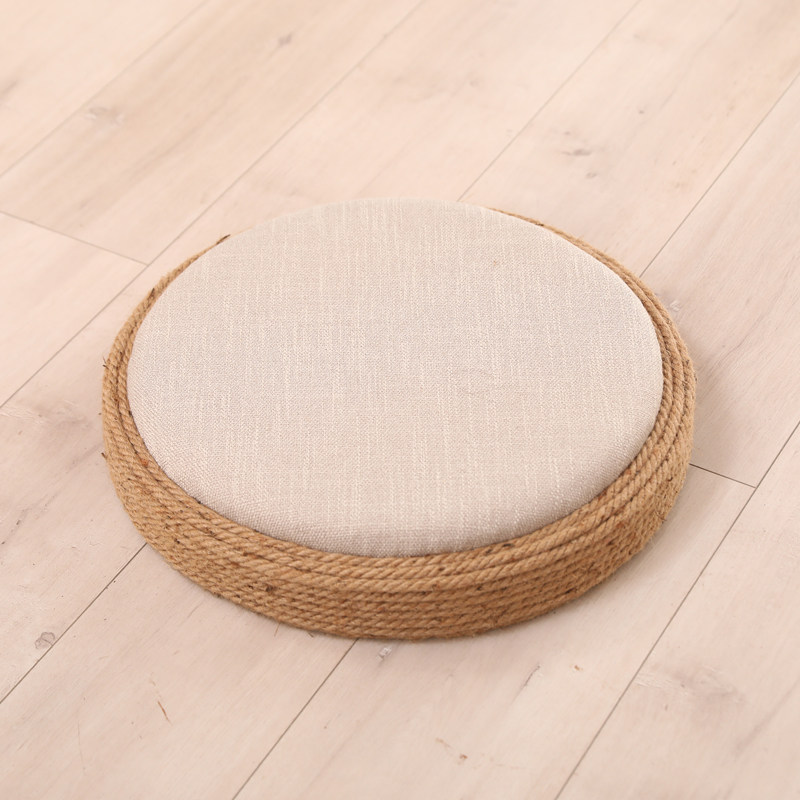 Beige round floor cushion with hemp rope border and natural linen cover, product shot