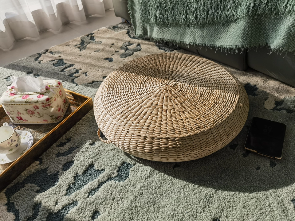 Close-up of handwoven bulrush cushion, showing natural fiber weave and carrying handle