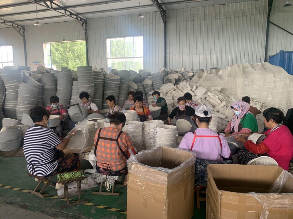Workers sort finished handcrafted cotton baskets in the main workshop of Woven Natural manufacturing plant