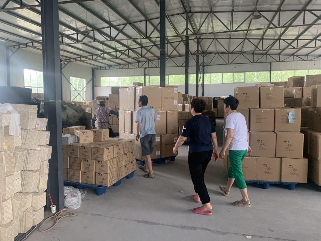 Workers arrange palletized finished cartons in Woven Natural’s large warehouse for wholesale pre-shipment orders