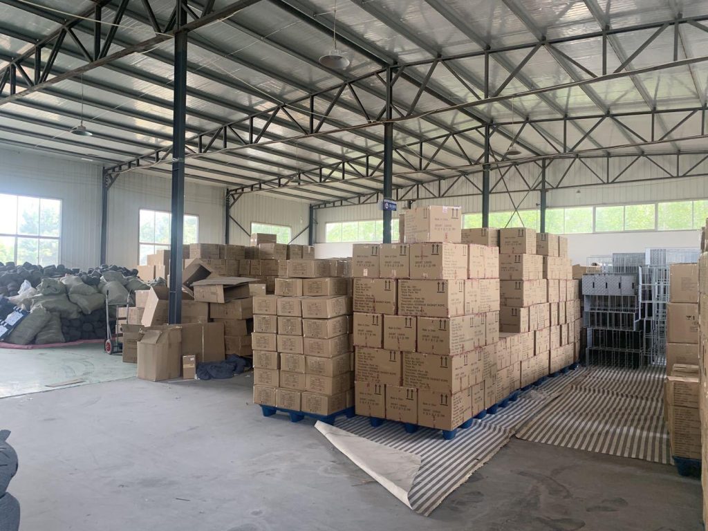 Pallet stacked cartons of finished natural fiber baskets stored inside Woven Natural bulk inventory warehouse