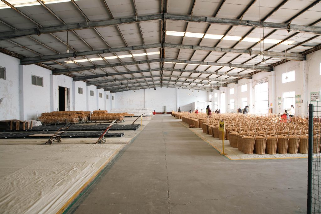 Wide view of Woven Natural factory workshop floor with neatly divided work zones and natural overhead lighting